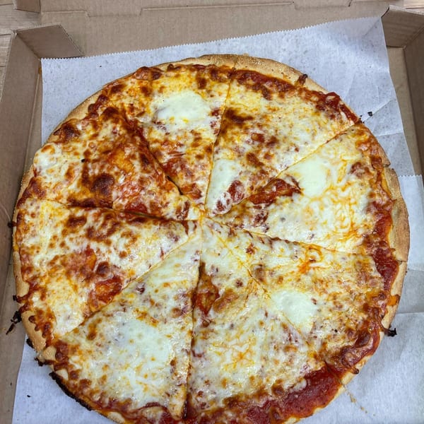 A whole Romano's Pizzeria cheese pizza, cut into eight slices, sits in a cardboard box.