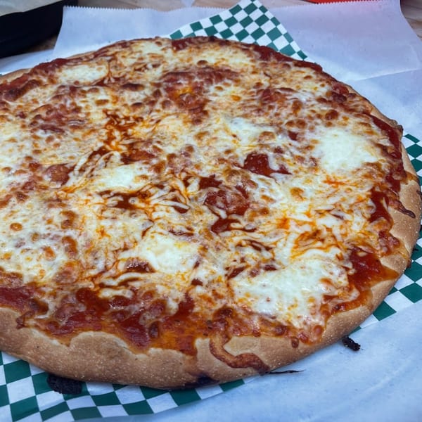 A whole Romano's Pizzeria cheese pizza with melted mozzarella and red sauce on checkered paper.